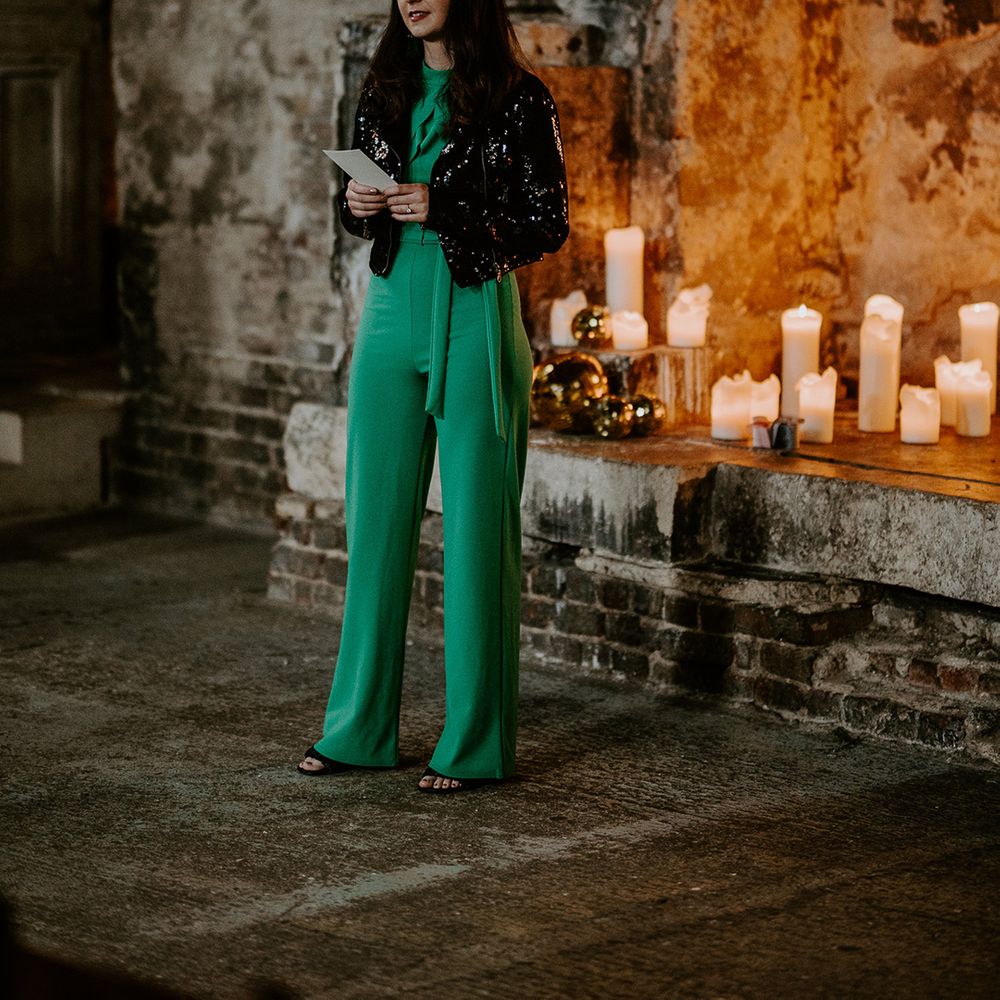Guest does wedding reading at unique London venue surrounded by candles for wedding lighting