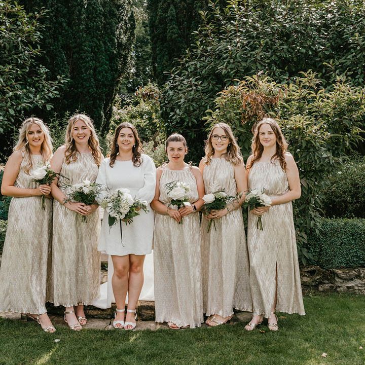 The bridesmaids wear shimmery gold bridesmaid dresses with halter neck style for monochrome black, white, and gold wedding 