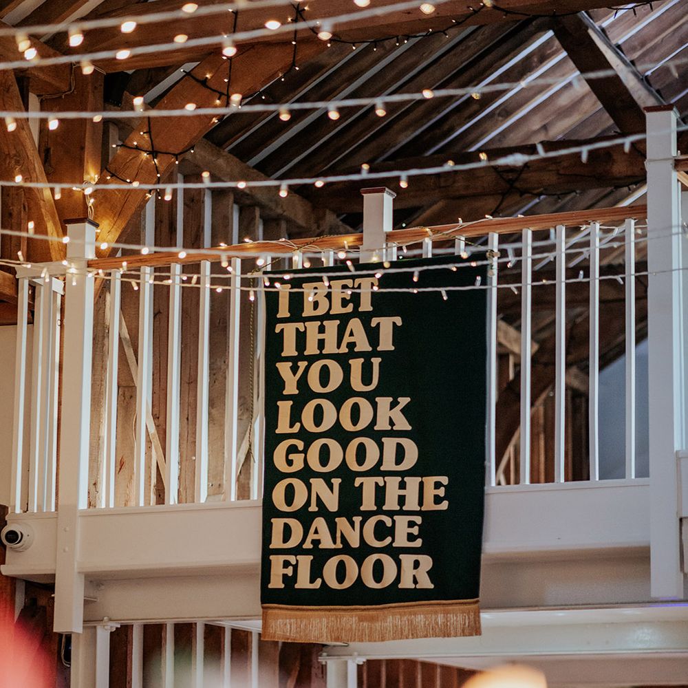 Large green and gold wedding banner decoration with lyrics of the bride and groom's first dance song on