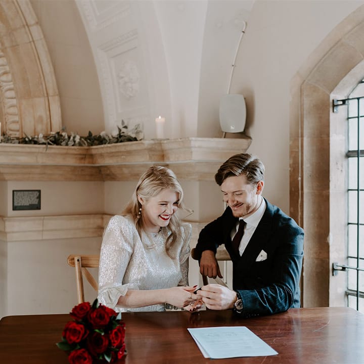 The bride and groom sign the register at Normanton Church for their gothic Halloween wedding 