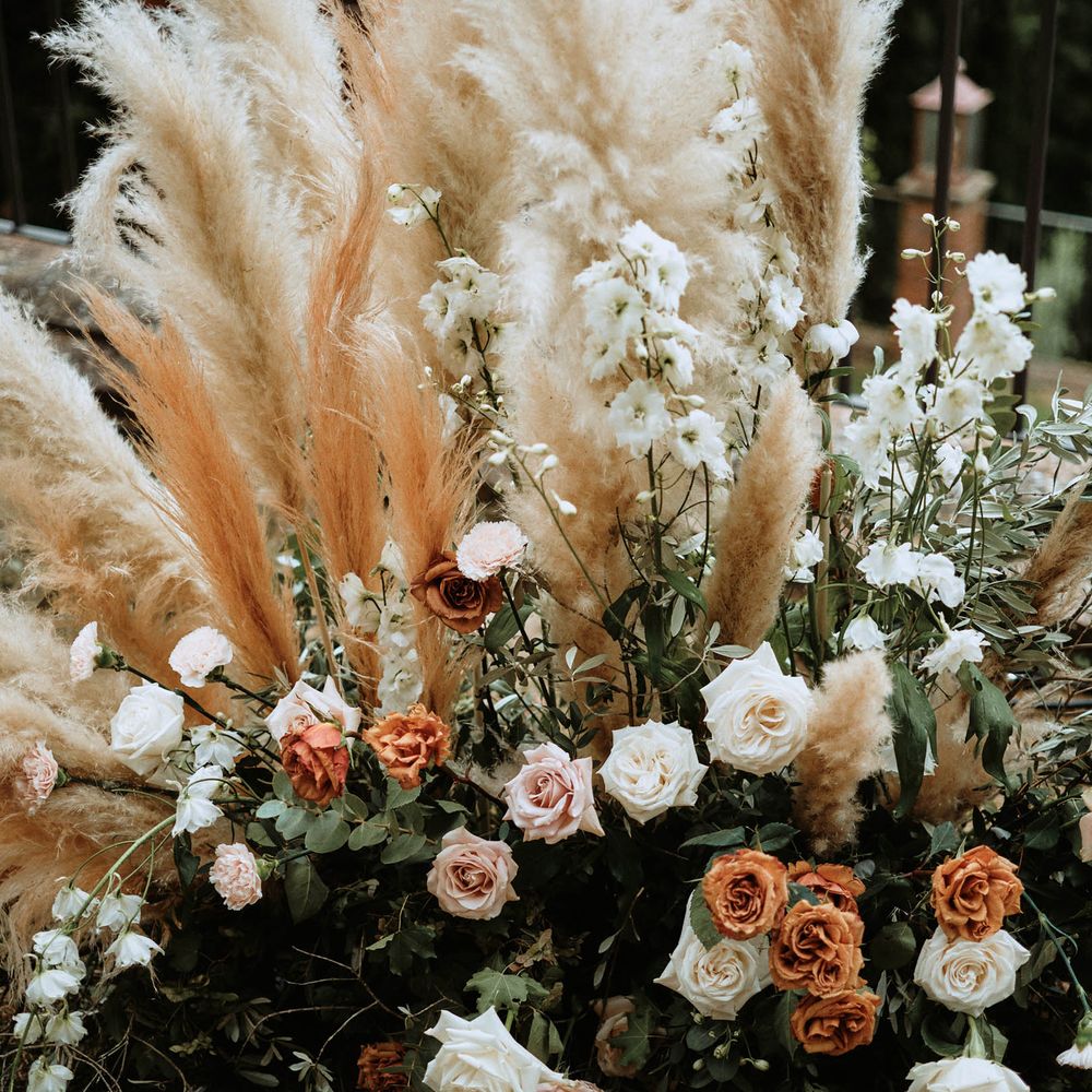 Peach and beige pampas grass decor with white carbonillo and pink, orange and white roses