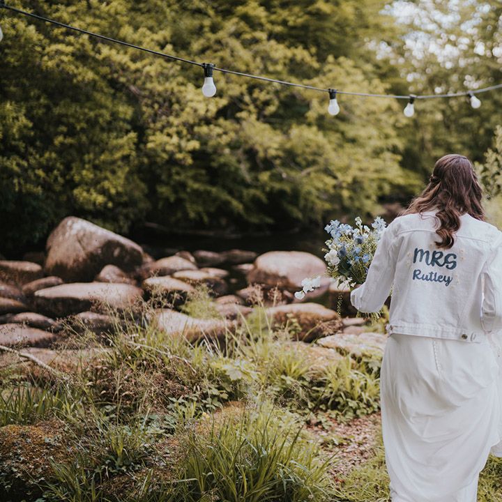 White denim jacket with DIY design on the back of the bride's new last name 