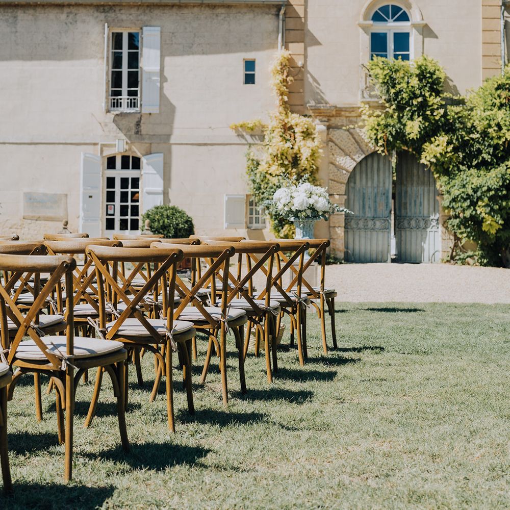 outdoor wedding ceremony at Château de Malliac with wooden chairs