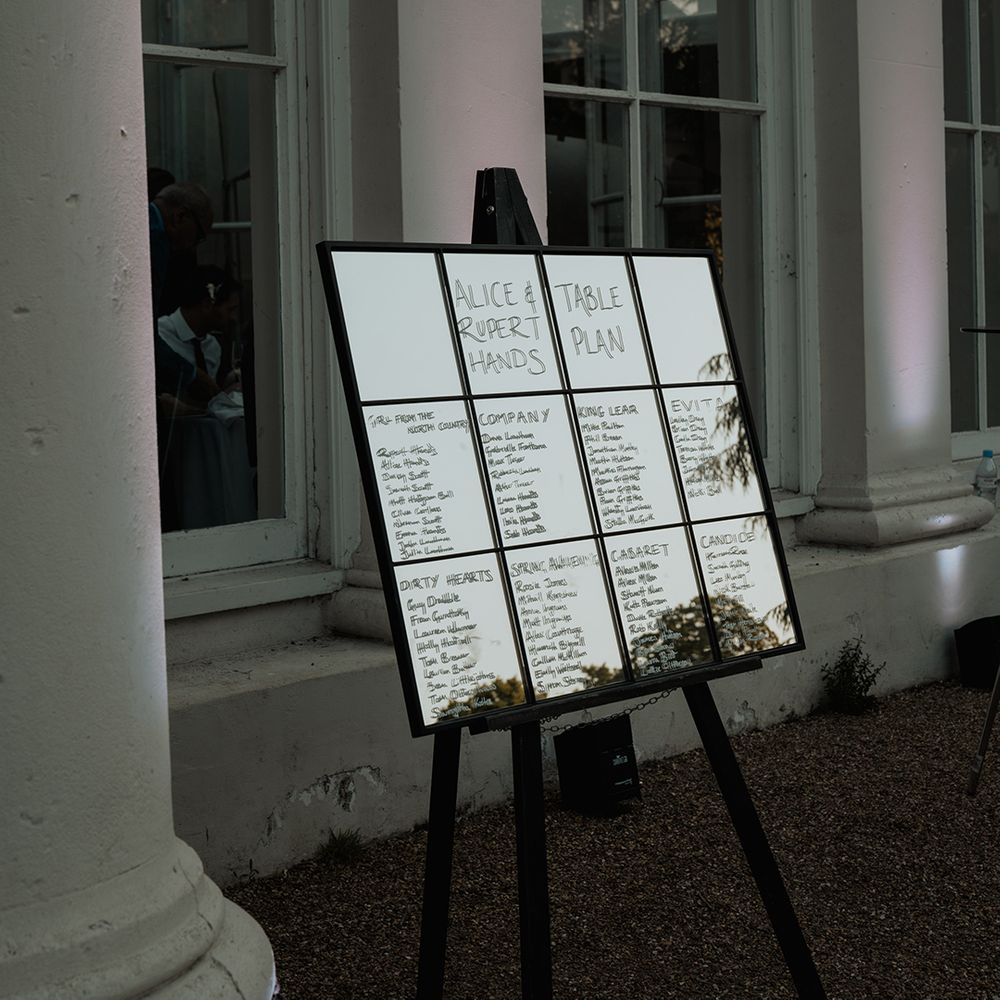 black window pane mirror table plan wedding decor on an easel 