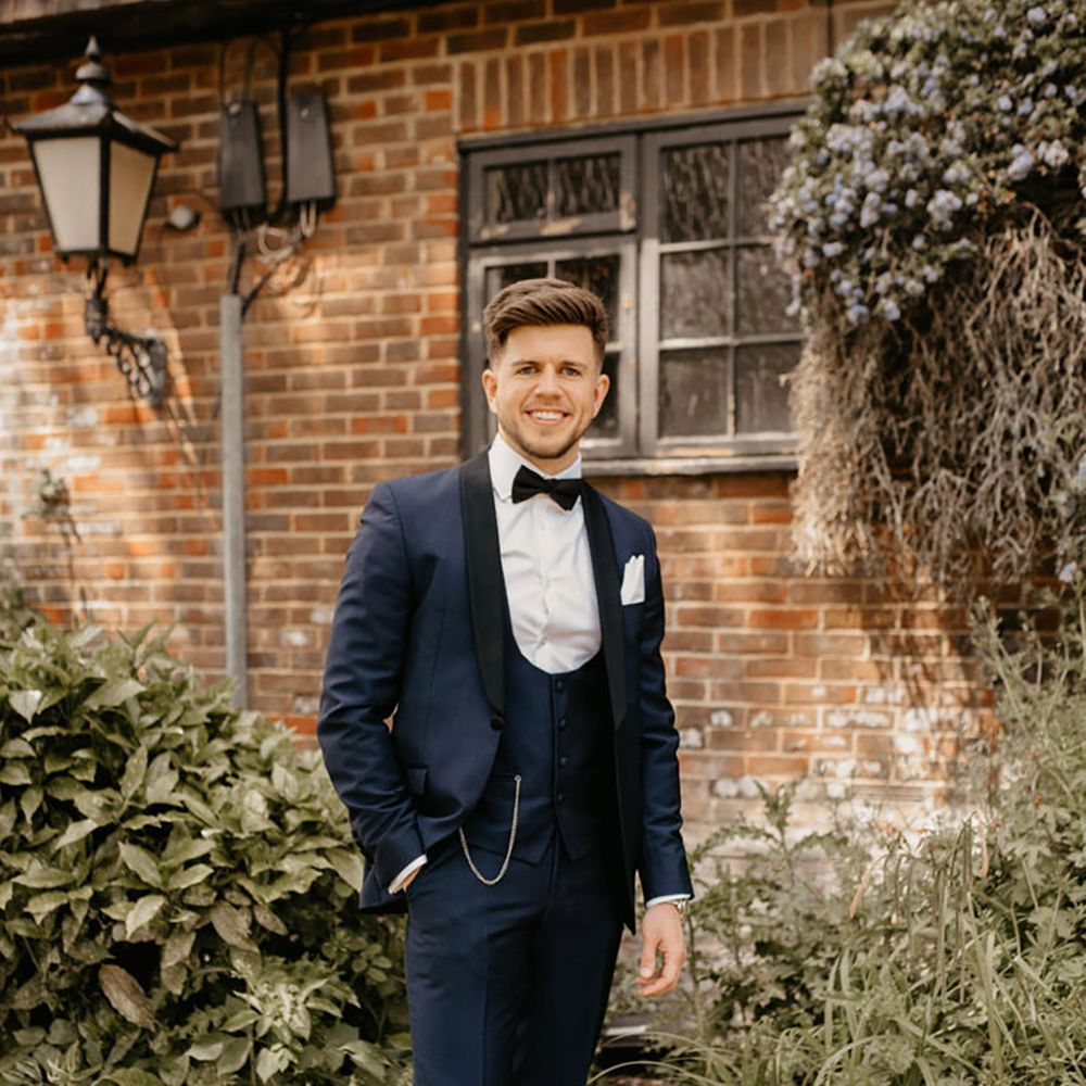 Groom wearing three piece blue and black wedding tuxedo with brown leather shoes for blue wedding theme 