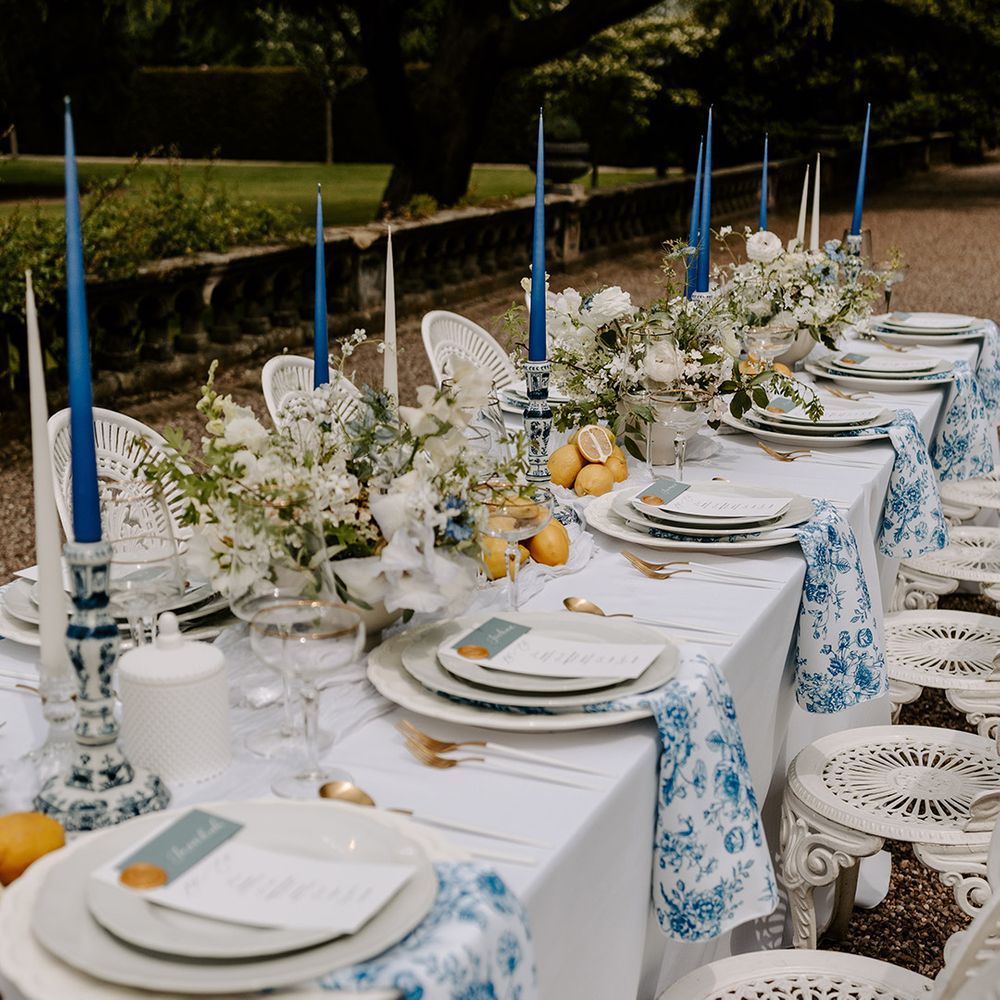 Luxe Capesthrone Hall wedding tablescape with lemons, blue and white floral patterned napkins and dark blue taper candles 