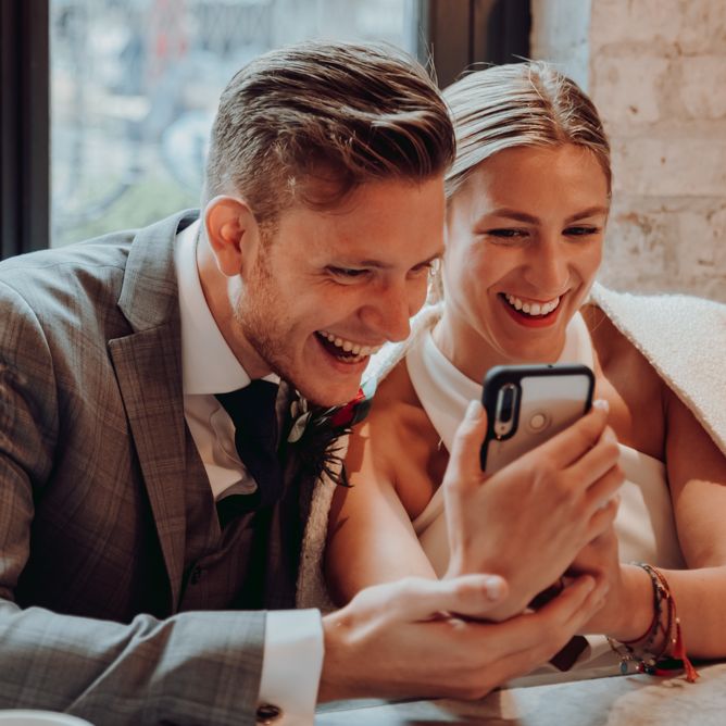 Bride and groom FaceTiming friends after their micro wedding 