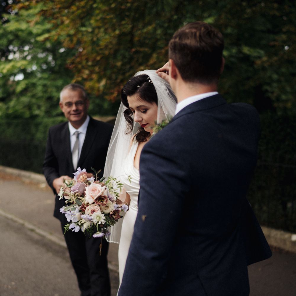 Groom helps bride remove confetti from hair