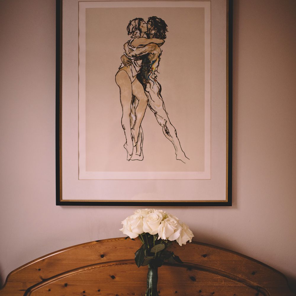 White rose classic floral bouquet with long stems are propped upon pillow