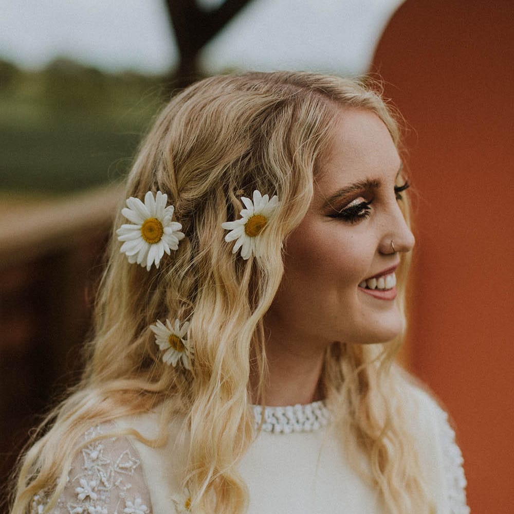 Beautiful bride with long wavy wedding hair and fresh flower decor