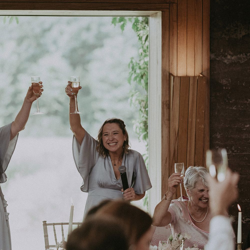 Bridesmaids raise their glasses on wedding day for bride & groom