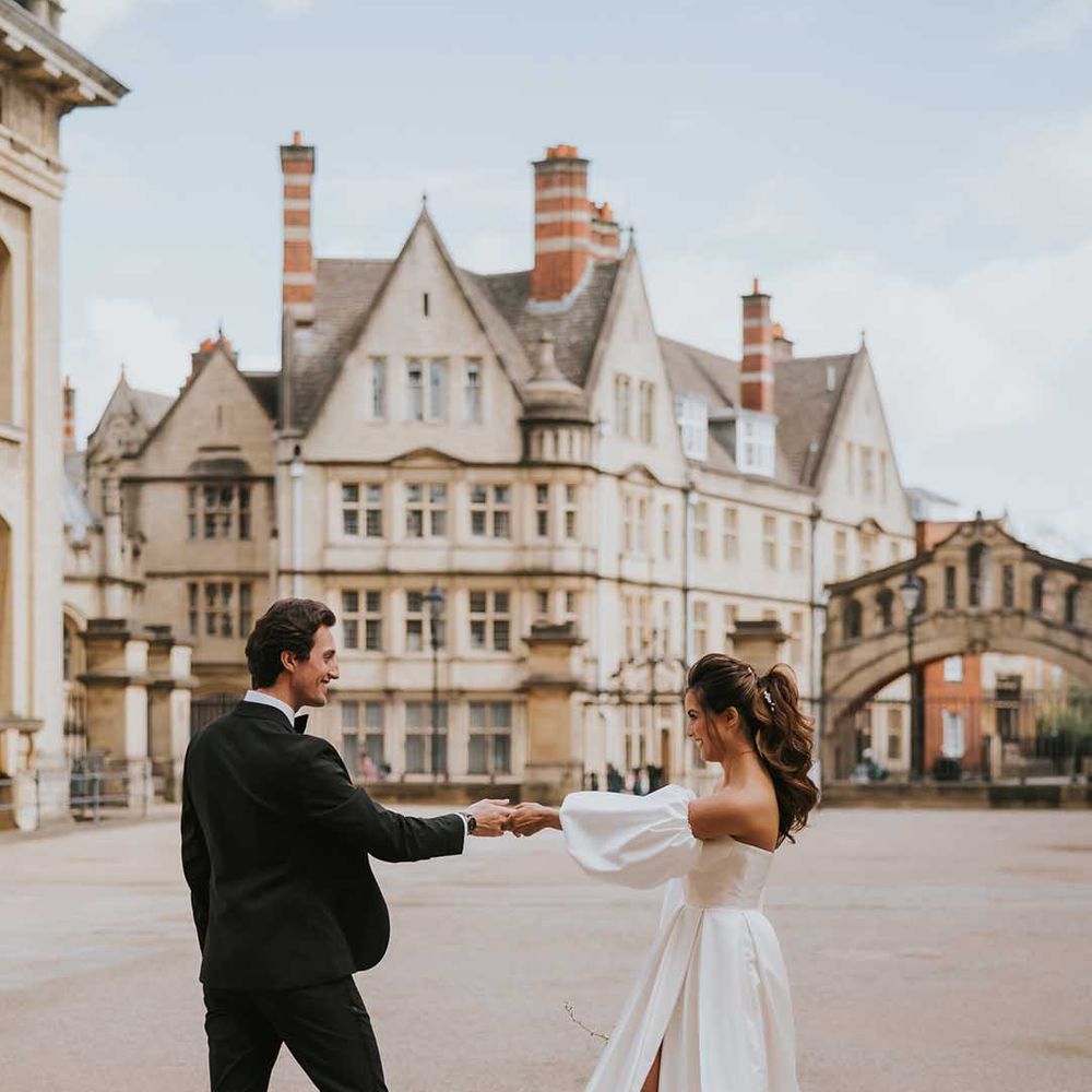 Bride with a high ponytail in a Nortier Shallow wedding dress with detachable sleeves in the courtyard at Bodleian Library 