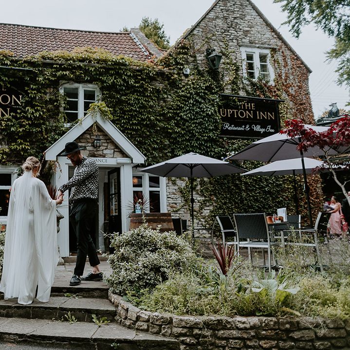 Bride walks up the steps to pub for reception on her wedding day