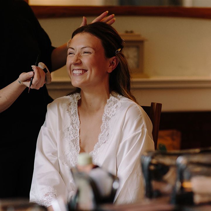 Bride gets her makeup done before wedding