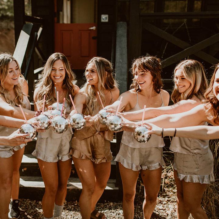 Bride celebrates with her bridesmaids who wear different styled gowns