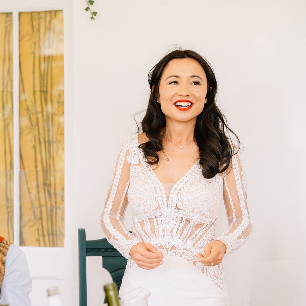 Bride in long sleeve illusion lace wedding dress stands and gives a speech at the wedding breakfast 