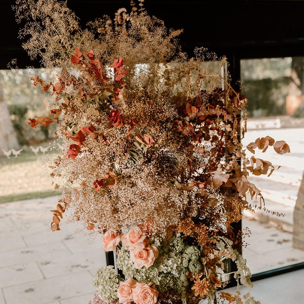 Rust and lavender wedding flower column with neutral colour palette and pops of colour 