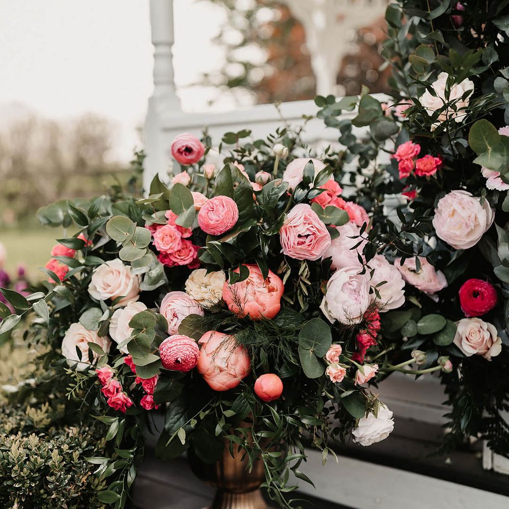 Pink wedding flowers decorating the outside for the outdoor ceremony at The Old Kent Barn