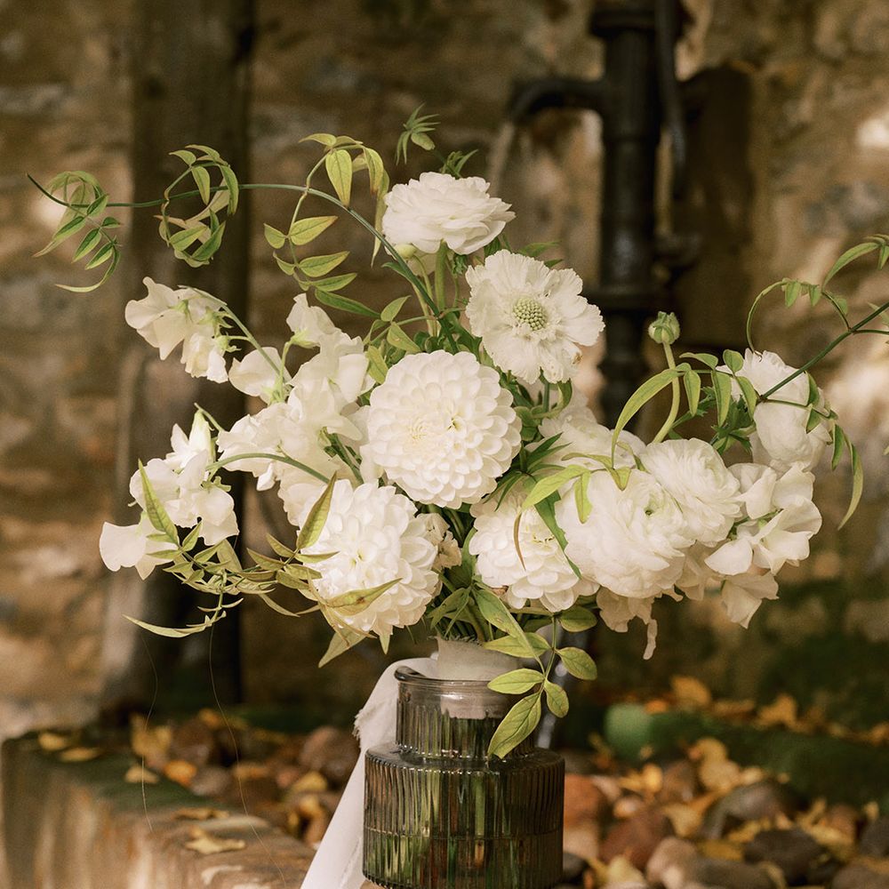 White dahlias and other white wedding flowers in an arrangement for a rustic luxe wedding at The Tythe Barn