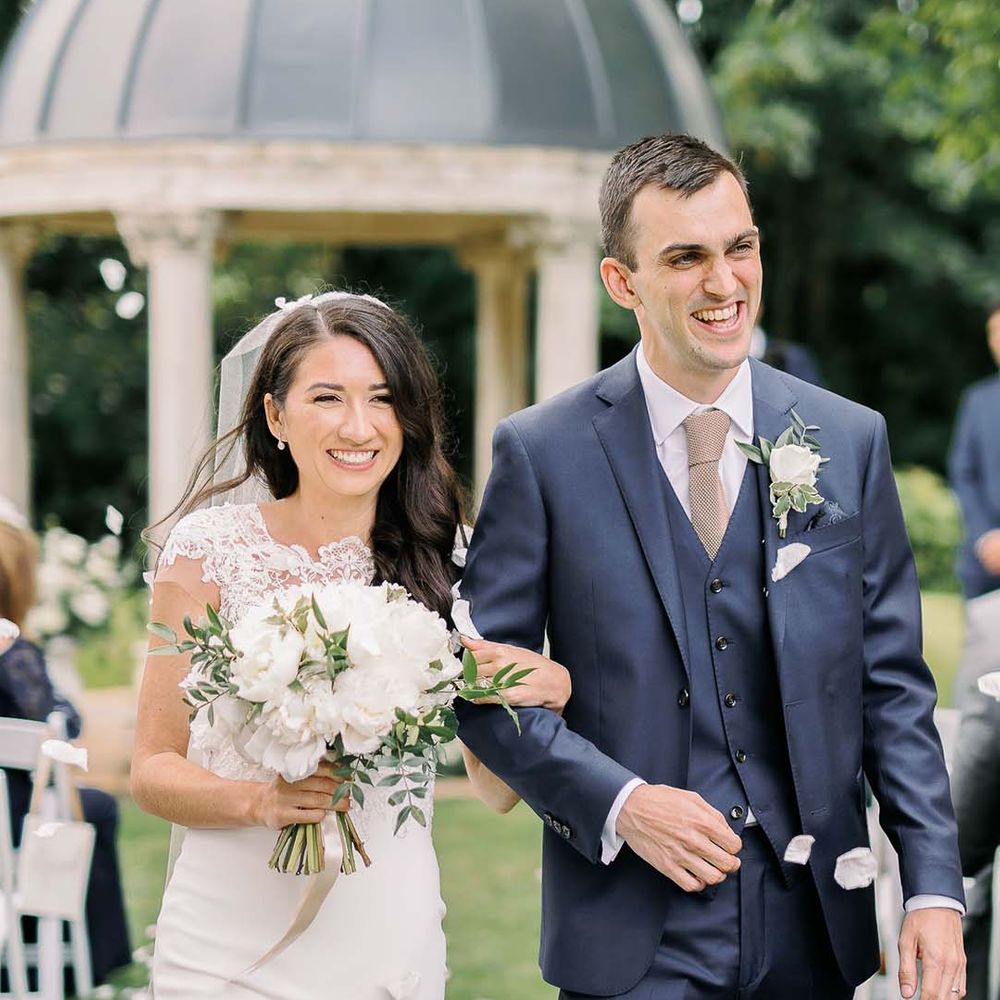 Bride in a Kelly Faetanini wedding dress holding a white wedding bouquet 