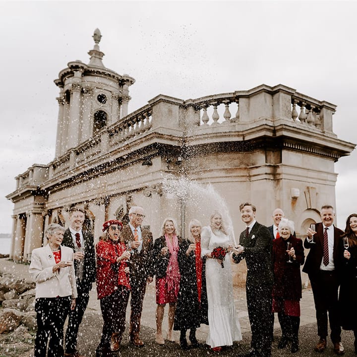Champagne popping moment at Normanton Church with the small intimate number of wedding guests 