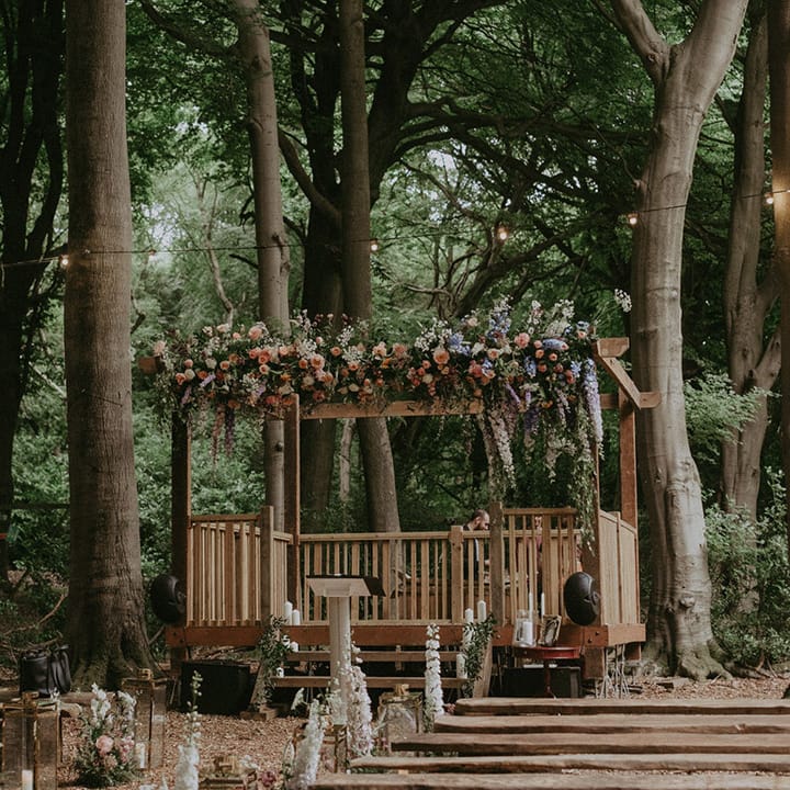 Lila's Wood woodland wedding venue with wooden gazebo decorated with pastel wildflowers for fairytale themed day 