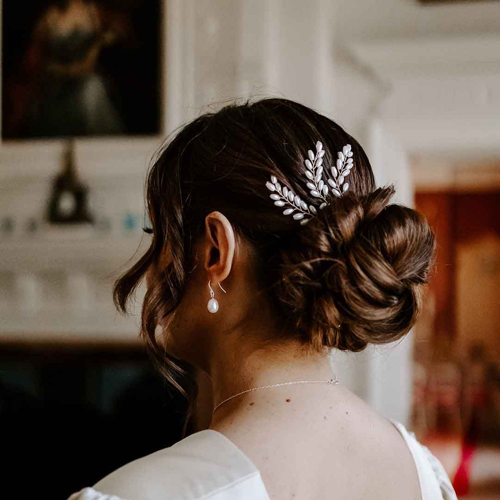 pinned bridal undo with shiny hair accessory 