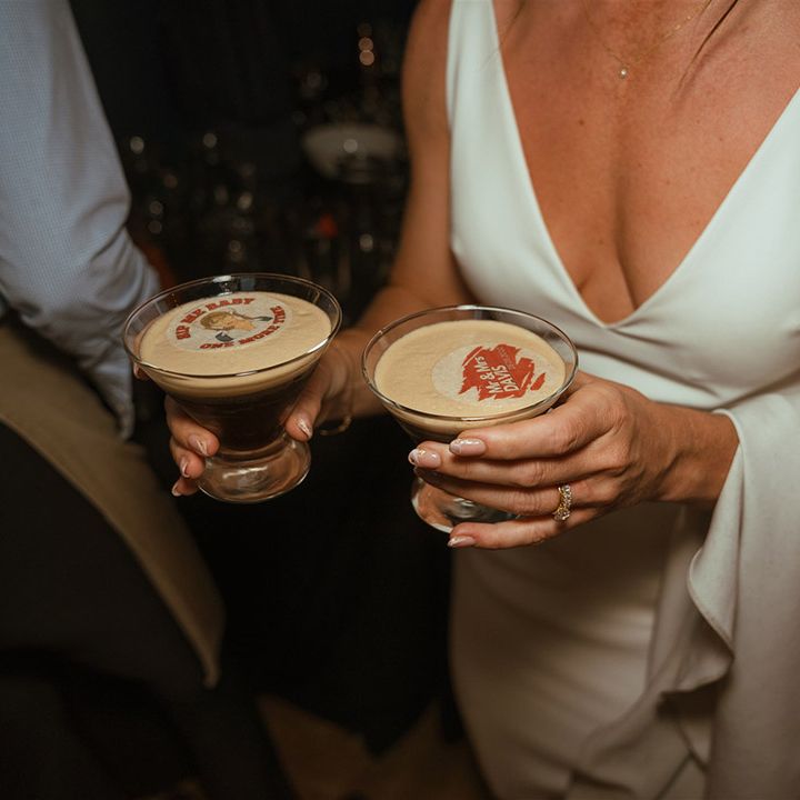 Bride holding espresso martini wedding cocktail with personalised edible toppers 