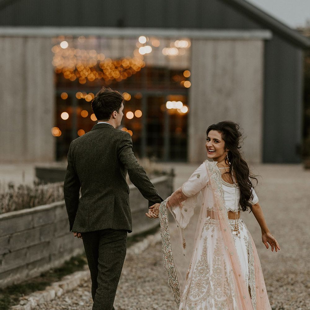 The bride and groom walk to their reception at Wharfedale Grange wedding venue in Yorkshire 