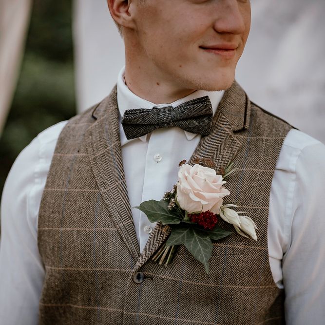 Groom in check waistcoat and bow tie at woodland wedding 