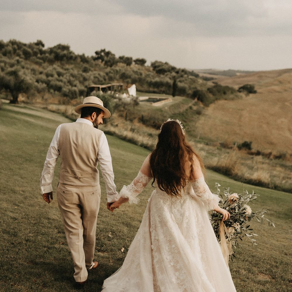 Bride and Groom holding hands with Olive bouquet after wedding