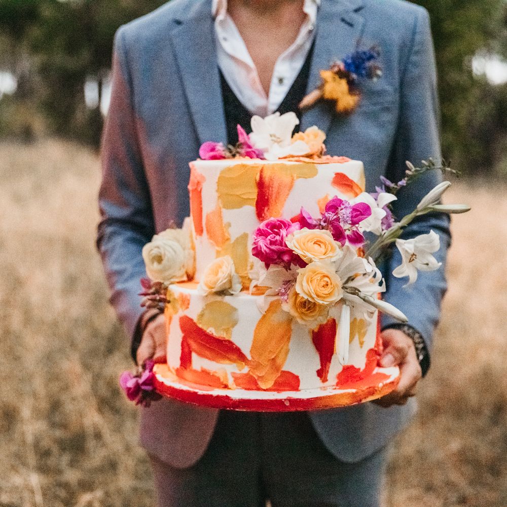 Wedding cake complete with bright and colourful decoration and florals