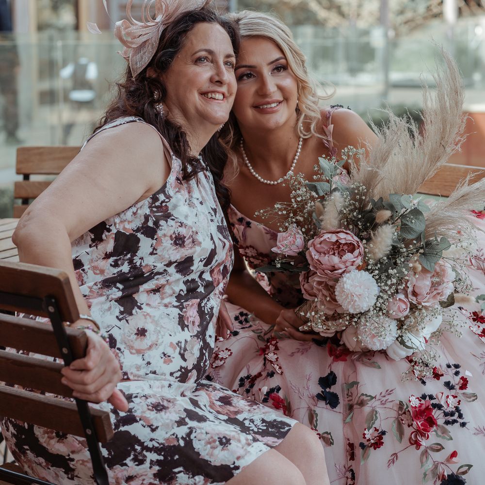 Bride sits with wedding guest on her wedding day