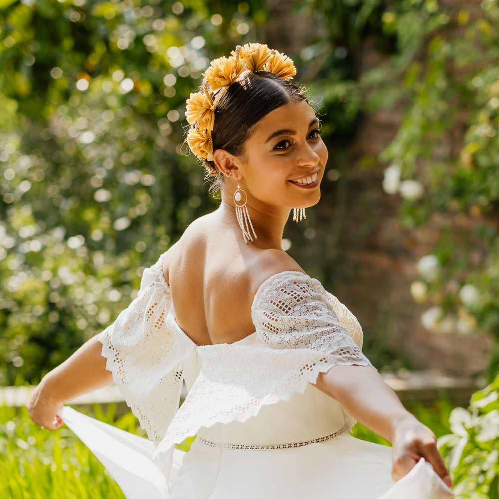 Boho bride twirling in a strapless wedding dress, yellow headband and tassel earrings 