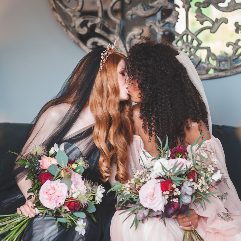 Autism marriage inclusive wedding inspiration with two brides kissing on the sofa in a black dress and pink bridal separates 