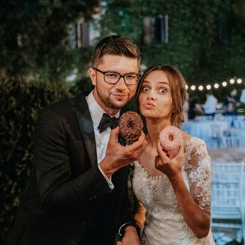 Bride & groom pose with donuts on their wedding day | Royal Studio