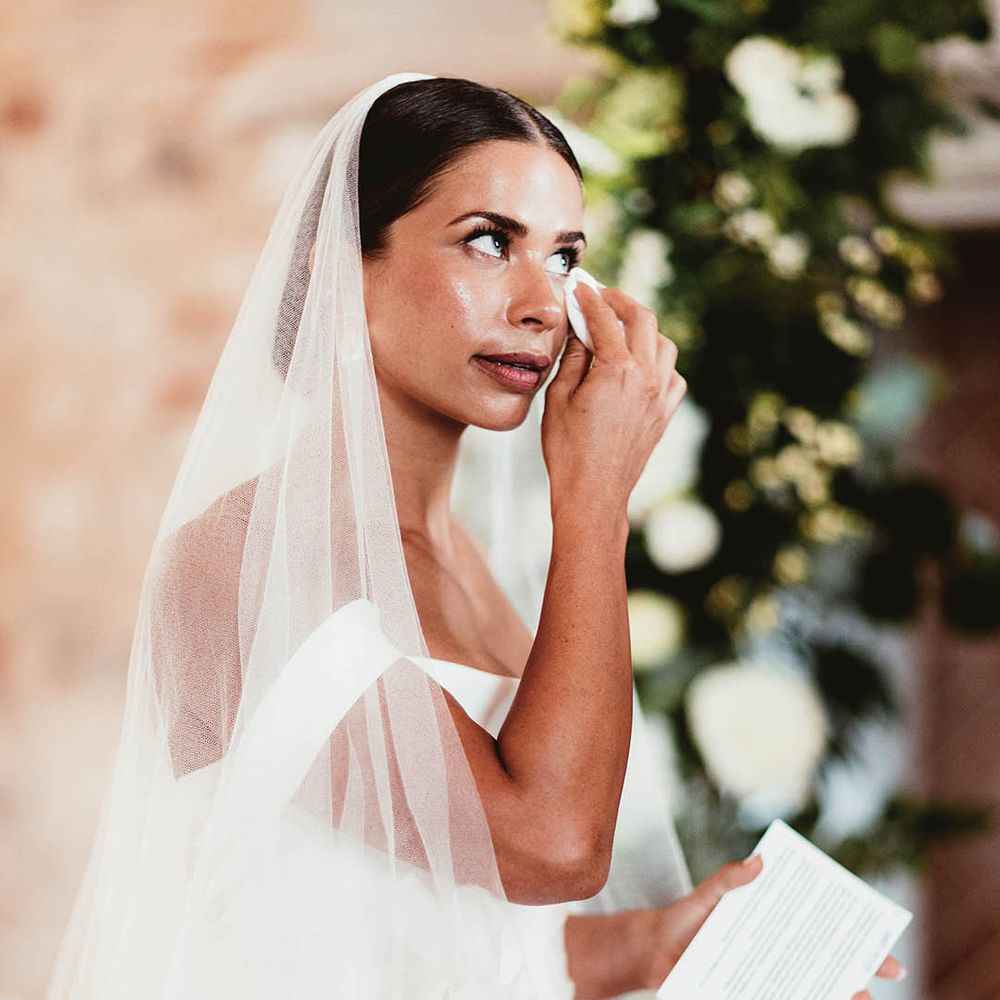 Bride becomes emotional during wedding ceremony as she dries her eyes with tissue