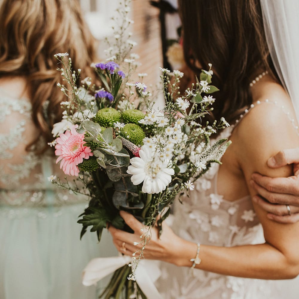 Bride holds white and pink floral bouquet 