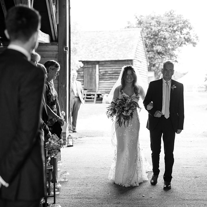 Bride walks down the aisle at barn ceremony