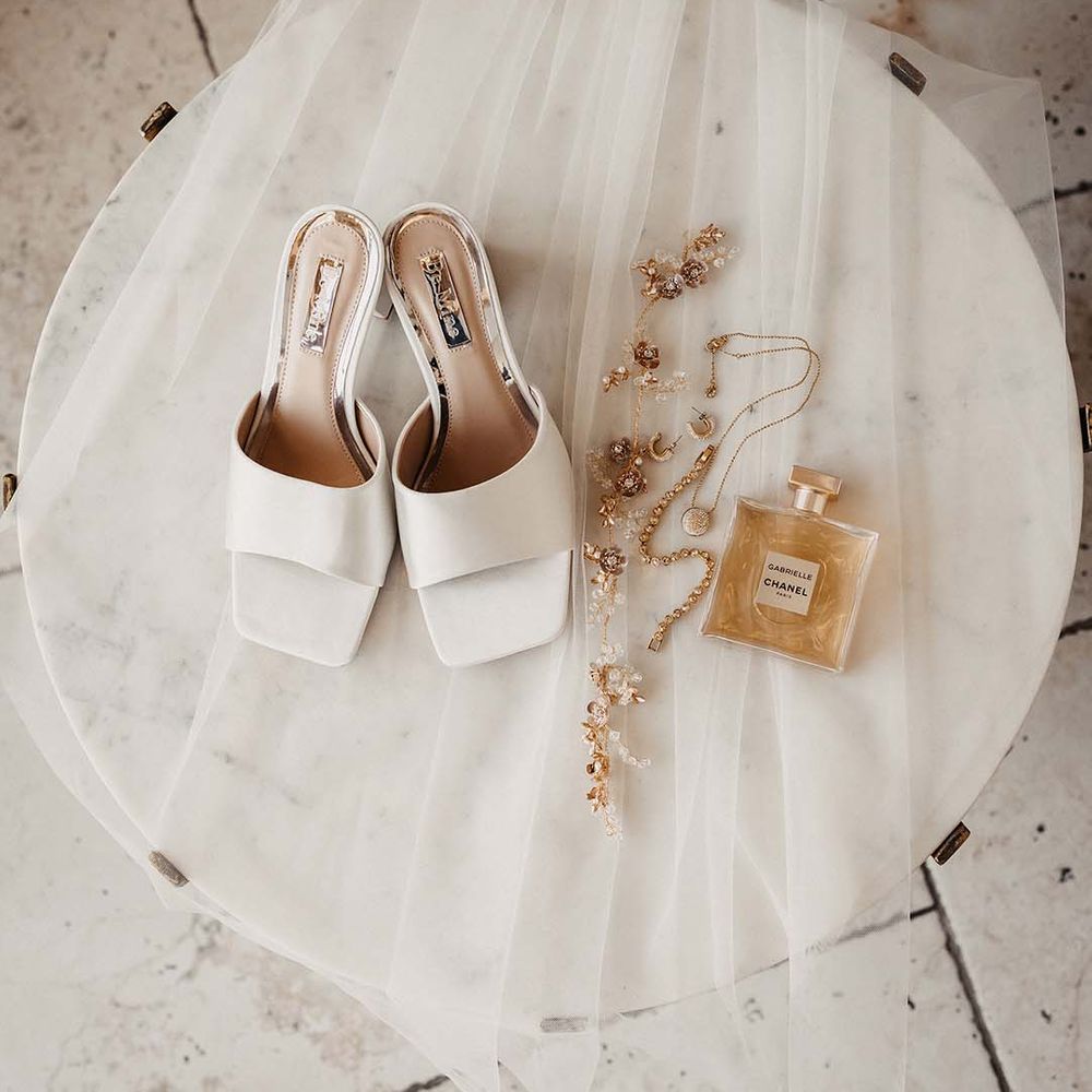 Bride's veil, gold jewellery, Chanel perfume and satin white mules