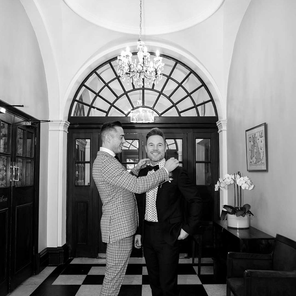 Grooms stand in Chelsea Old Town Hall on their wedding day