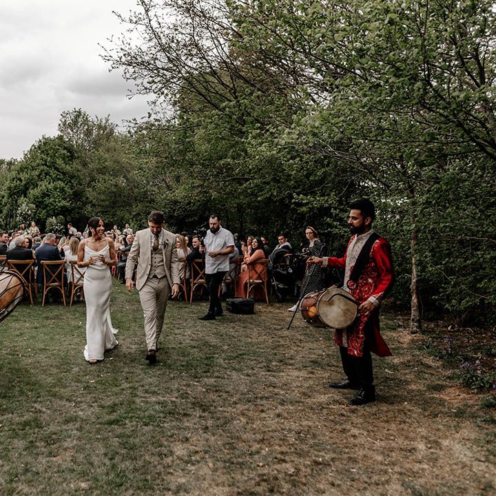 Bride and groom descending up the aisle as husband and wife with Dohl drummers playing 