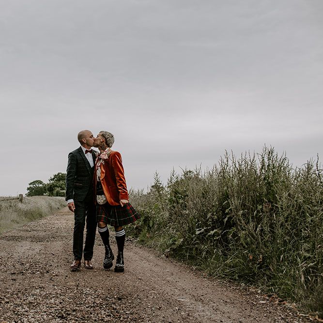 Grooms kiss in the road on their wedding day outdoors 