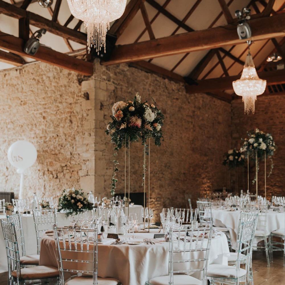 Reception room of Notley Abbey with glass chairs and large wooden beams