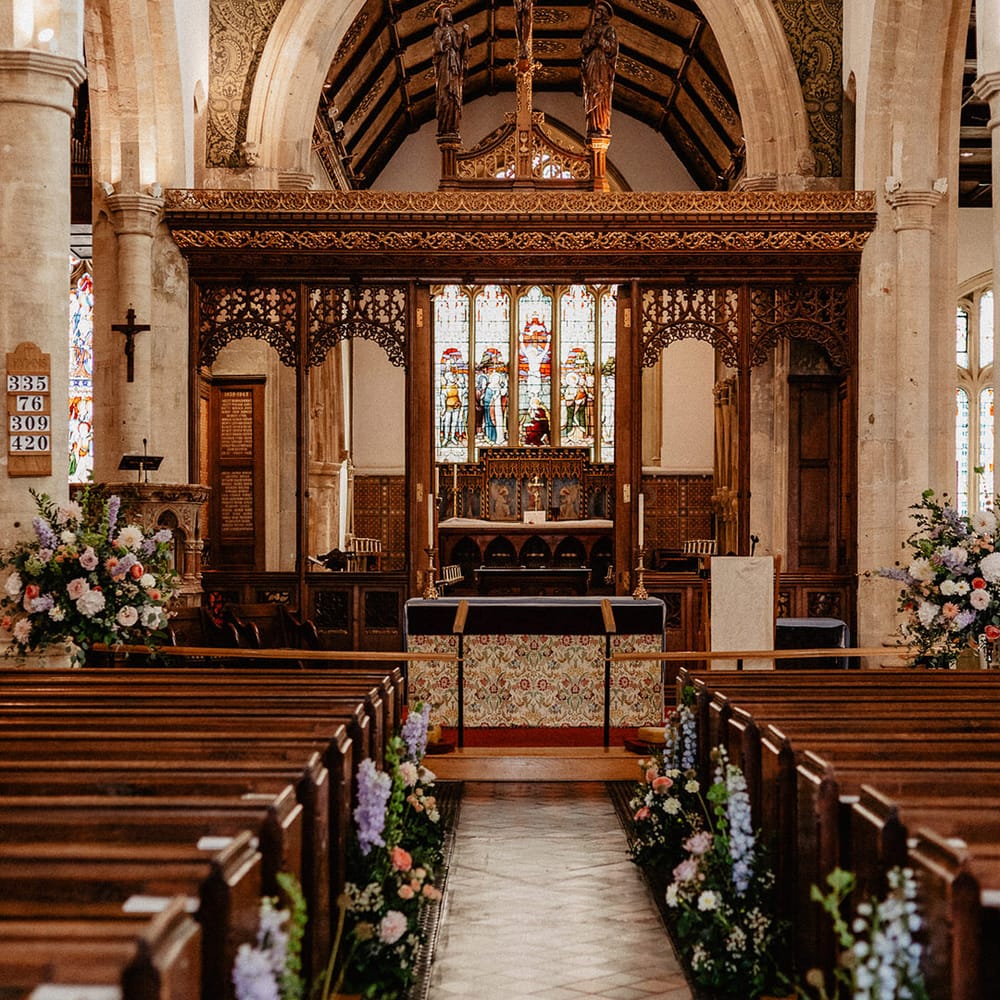 Traditional church wedding with pastel wildflower aisle decoration 