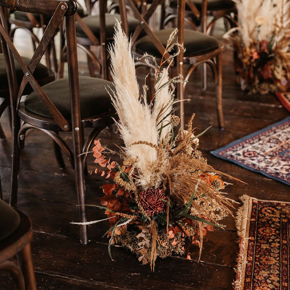 Dried floral arrangements with pampas grass line aisle at The Dreys wedding venue 
