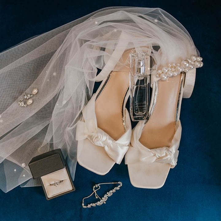The bridal accessories with a pearl shoulder length veil, pearl earrings, diamond bracelet and necklace with white square toe bow wedding shoes