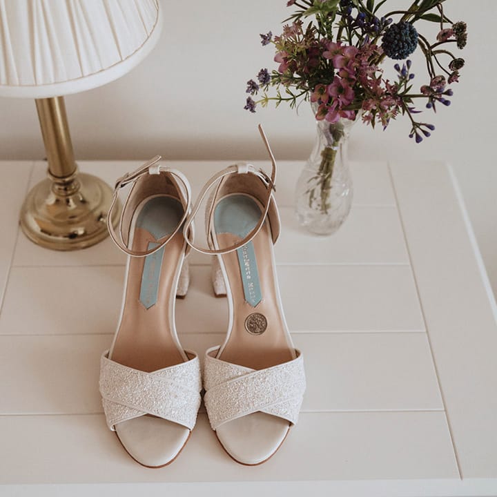 Open toe Charlotte Mills white glitter heels with an ankle strap for the bride 