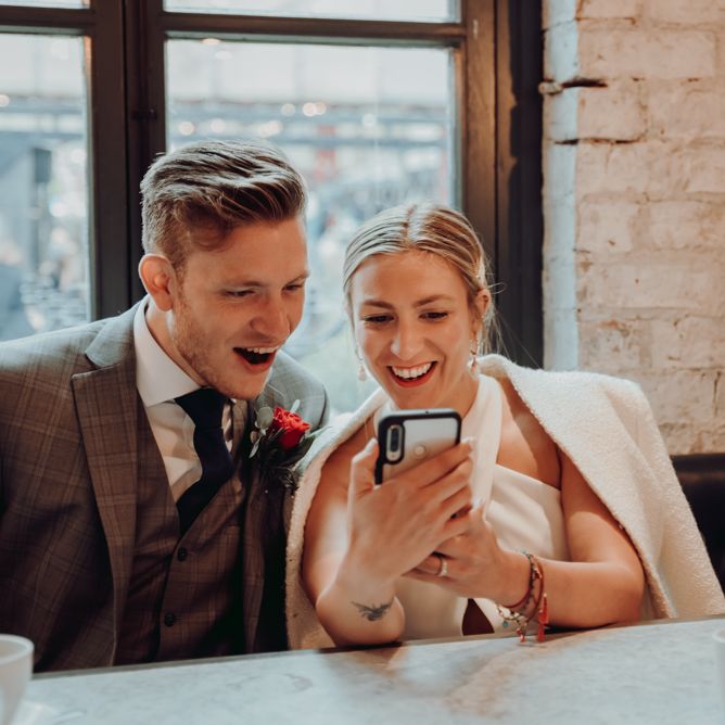 Bride and groom reading messages from guests who couldn't attend their micro wedding 