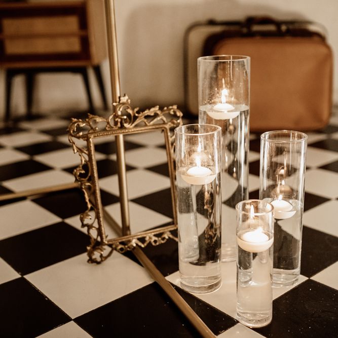 Suspended candles next to golden frame